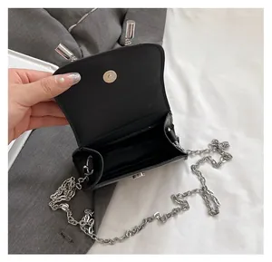 Internal view of the mini black chain bag showing a single compartment for lipstick