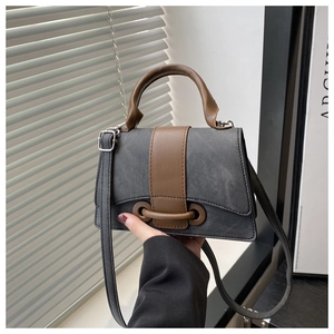 Close-up of contrast grey and brown leather bag with silver metal buckle and handle