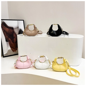 Minimalist crescent handbags in five colors displayed on elegant white podiums