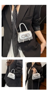 Détail du mini sac argenté montrant le nœud en strass et la bandoulière en chaîne métal
