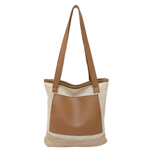 Large woven straw tote bag with brown leather pocket and handles for beach and commute