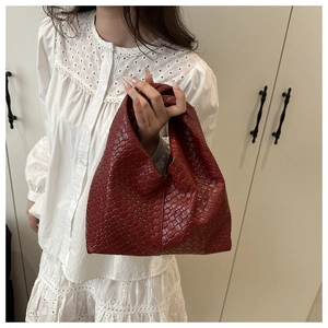 Detail of red woven leather hobo bag showcasing intricate Intrecciato craftsmanship