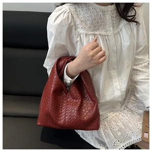 Close-up of dark red woven leather underarm bag featuring intricate craftsmanship