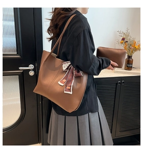 Detail of brown leather tote bag with silk scarf and matching inner pouch clutch