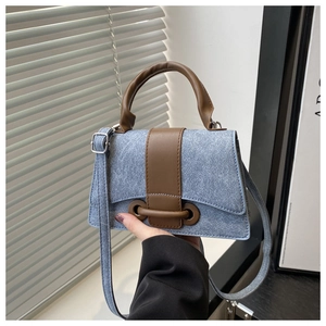 Detail showing denim texture and brown PU leather handles of this vintage small square bag