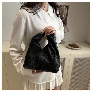 Detail of the black woven leather hobo bag showcasing intricate craftsmanship and texture