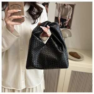 Detail of black woven leather tote bag featuring artisan Intrecciato craftsmanship