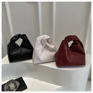 Close-up of woven leather shoulder bags featuring unique knotted handle craft details