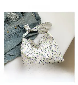 Detail of floral canvas tote bag with purple flower print and creative knotted shoulder strap