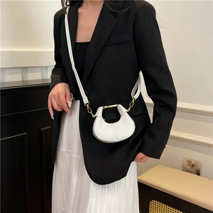 Chic white crescent moon bag with gold metal handle and slim adjustable crossbody strap