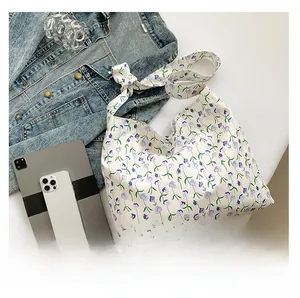 Floral hobo tote bag flat lay showing capacity with a tablet and denim jacket