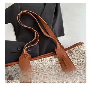 Close-up of the woven texture and reinforced brown leather handle on a large tote bag