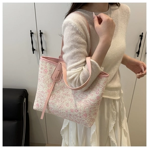 Detail of pink and white woven tote bag featuring geometric heart patterns and faux leather handles
