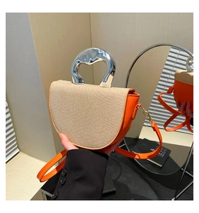 Detailed mirror view of half-moon saddle bag with orange leather and woven texture