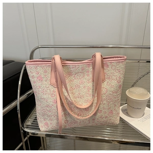 Detailed macro view of pink and beige woven texture on large tote bag with leather handles