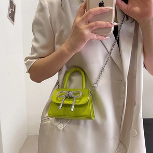 Mini sac bandoulière vert citron avec nœud en cristal et chaîne argentée sur modèle