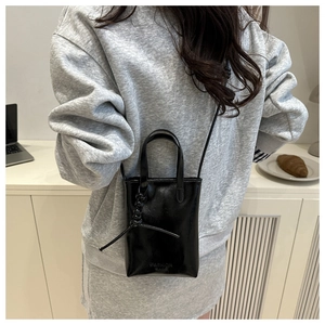 Close-up of a black glossy mini crossbody bag with Fashion Bag text and handle