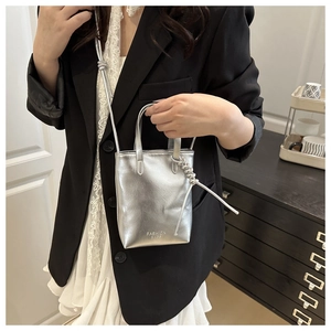 Mini sac bandoulière argenté métallisé porté par un mannequin avec texte gravé