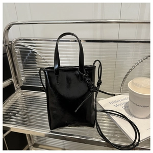 Glossy black patent leather tote bag with Fashion Bag embossing on metallic shelf