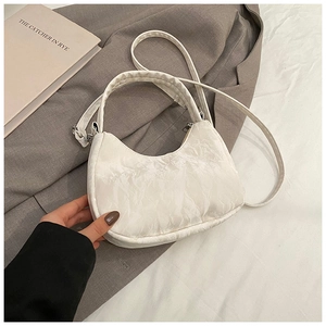 Detail of white hobo bag with marble texture, silver hardware and crossbody strap