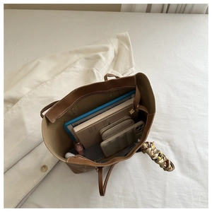 Detailed interior of large brown tote bag showing spacious space for tablets and wallets