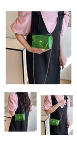 Three-way view of green transparent jelly bag with golden chain and snap closure