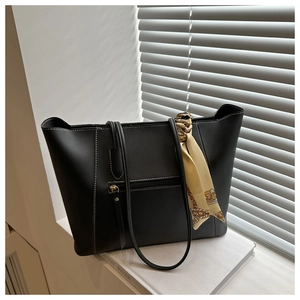 Detail of black large tote bag with contrast stitching and decorative yellow silk scarf