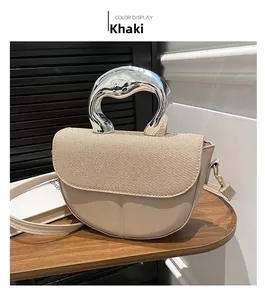 Close-up of khaki saddle bag with woven texture flap and metallic silver handle
