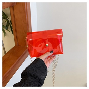 Detail of red transparent jelly chain bag with gold metal button and envelope flap closure