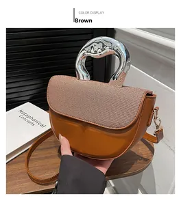 Detail of brown saddle bag featuring woven flap, leather base, and silver metal handle