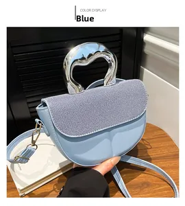 Detail of blue saddle bag with striped fabric inlay and liquid silver metal handle
