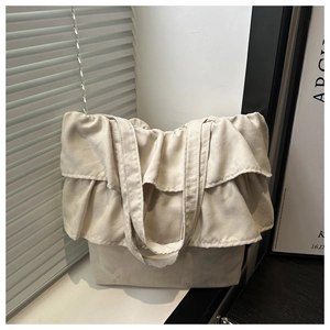 Detail of beige canvas tote bag with ruffled edges against a minimalist home background