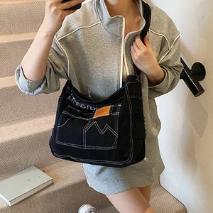 Borsa a tracolla in tela nera con cuciture a contrasto e multitasche in stile workwear
