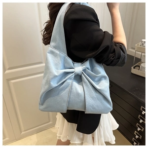 Detailed back view of a light blue denim tote bag with a stylish large bow decoration