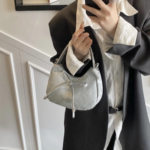 Silver crescent underarm bag with bow decoration and metallic Dior logo charm