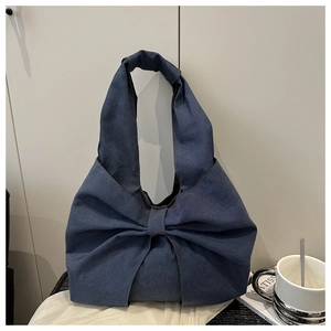 Close-up of a dark blue denim tote bag featuring a stylish oversized bow and large capacity