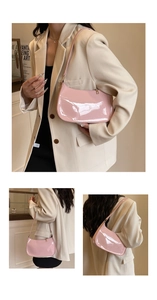 Detail of pink patent leather hobo bag showing glossy finish and sleek shoulder strap
