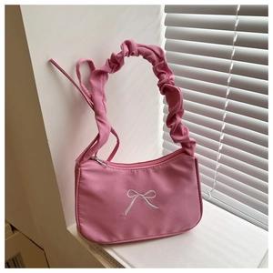 Gros plan sur le sac baguette rose plissé avec détail de nœud brodé blanc délicat