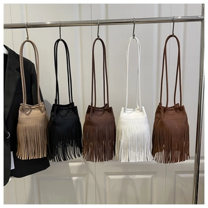 Row of leather tassel bucket bags in khaki, black, brown, white and caramel on display