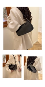Detailed view of black patent leather hobo bag with glossy finish and moon shape