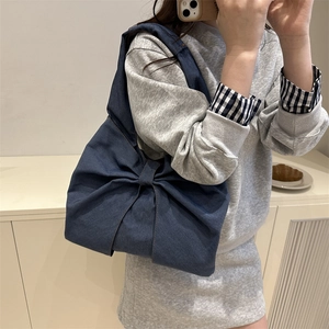 Dark blue denim shoulder bag with a large oversized bow design for modern casual style