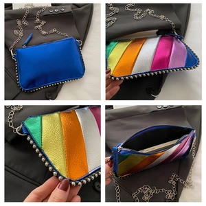 Macro view of blue metallic rainbow stripe clutch with silver stud rivets and chain strap