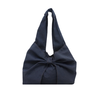 Deep blue denim tote bag with oversized bow design and stylish shoulder strap