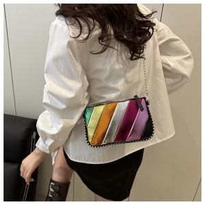Rainbow striped crossbody bag with studs and chain strap shown on a model's shoulder