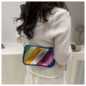 Detail of metallic rainbow striped crossbody bag with silver bead chain and metal strap