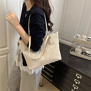 Minimalist cream woven tote bag with V-shaped texture for women on shoulder