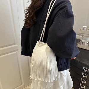 White bucket bag with fringe tassels and thin leather straps for casual wear
