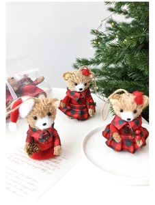 Detail of sisal Christmas bear ornament with red and green plaid outfits and festive pinecone