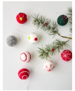 Macro detail of handmade wool felt Christmas snowflake balls with hanging strings