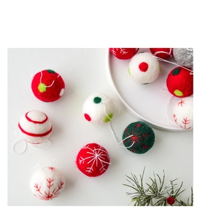 Detailed view of handmade wool felt Christmas balls with festive snowflake embroidery